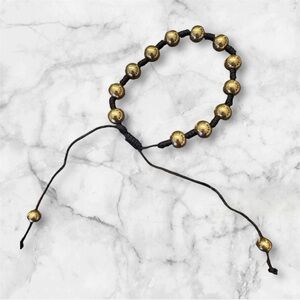 Black string bracelet with gold tone stainless steel beads. NEW